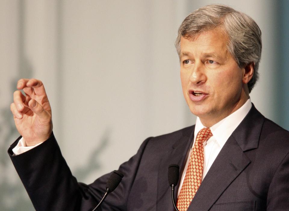 Jamie Dimon gestures with his right hand as he speaks into a microphone.