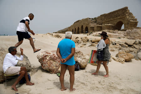 Beachgoers are seen on the beach near the aqueduct in the Old City of Caesarea, Israel, April 26, 2017. REUTERS/Amir Cohen TPX IMAGES OF THE DAY