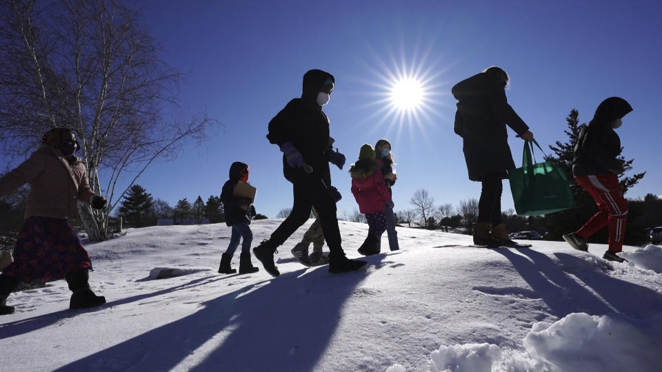 In this Monday, Dec. 8, 2020 photo, Cindy Soule's fourth grade class heads outside to study snowflakes at the Gerald Talbot School, in Portland, Maine. A number of schools in Maine and elsewhere across the country plan to keep outdoor learning going all winter long, with students trading in warm classrooms for fresh, frigid air.(AP Photo/Robert F. Bukaty)