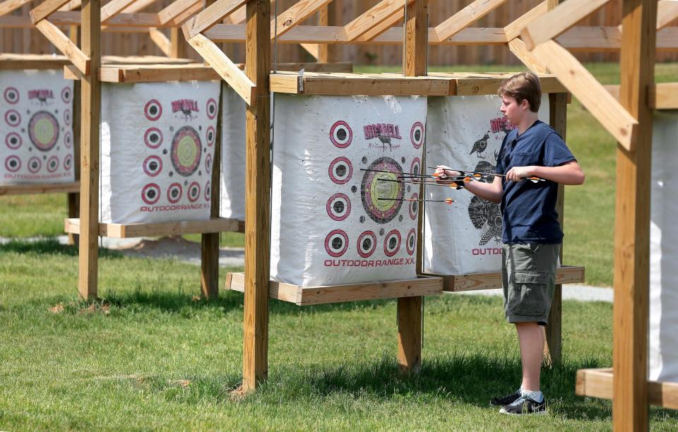 Anthony Garcia of Westfield retrieves his arrows from a target at the Strawtown Koteewi Sport & Target Archery Range on Saturday, May 30, 2015.