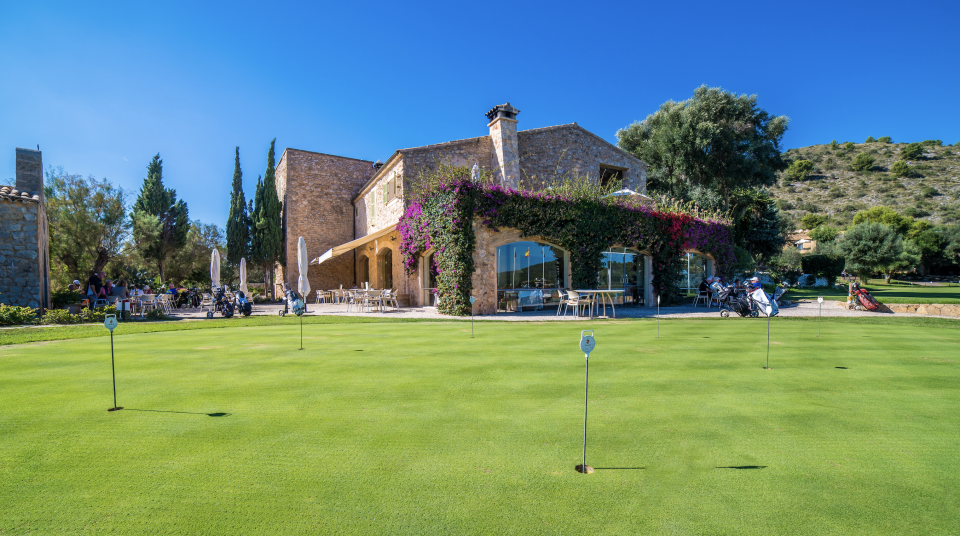 Practice putting green and clubhouse at Pula