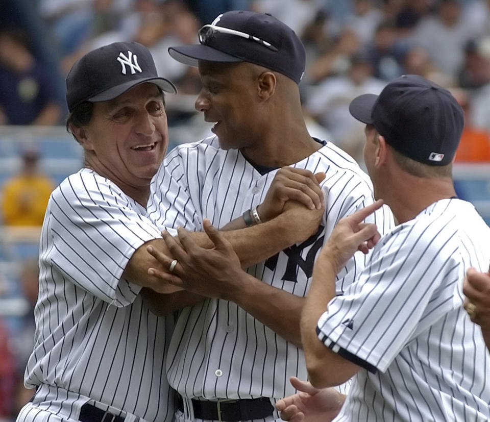 FILE - Former New York Yankees baseball player Joe Pepitone, left, hugs Darryl Strawberry as David Cone, right, looks on during Old-Timers' Day, June 24, 2006, at Yankee Stadium in New York. Pepitone, a key figure on the 1960s Yankees who gained reknown for his flamboyant personality, has died at age 82. He was living with his daughter Cara Pepitone at her house in Kansas City, Mo., and was found dead Monday, March 13, 2023, according to BJ Pepitone, a son of the former player. (AP Photo/Bill Kostroun, File)