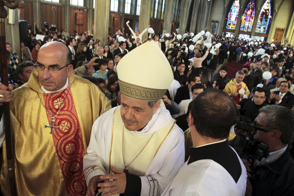 Bishop Juan Barros, center, attends his first religious service as citizens protest at the Osorno cathedral south of Santiago on March 21, 2015. (Photo: Carlos Gutierrez / Reuters)