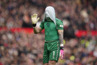Everton's goalkeeper Jordan Pickford covers his head with his shirt during an English Premier League soccer match between Manchester United and Everton at the Old Trafford stadium in Manchester, England, Saturday, March 9, 2024. (AP Photo/Dave Thompson)