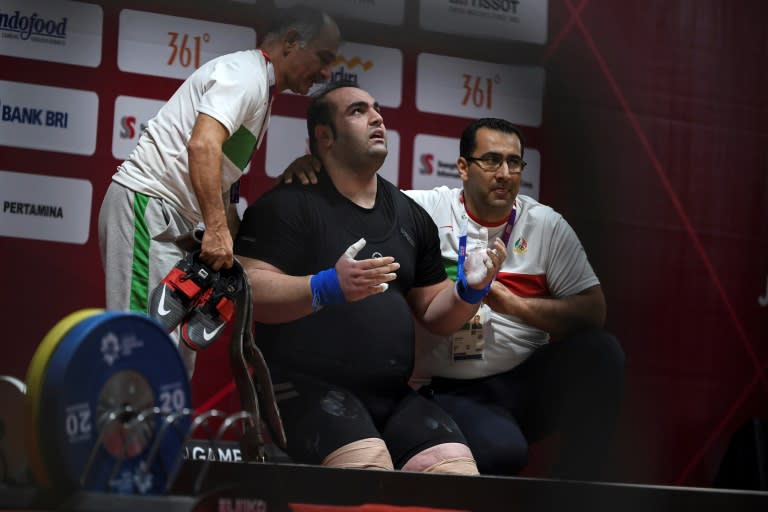 Iran's Behdad Salimikordasiabi (C) reacts as he competes in the men's +105kg weightlifting event during the 2018 Asian Games in Jakarta on August 27, 2018