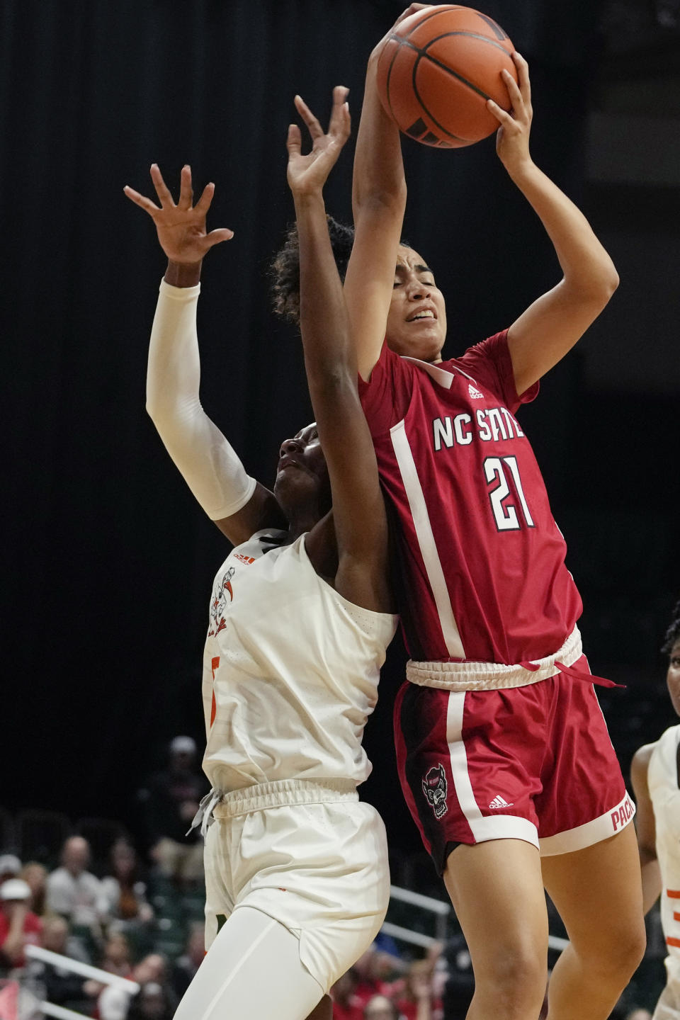 Miami guard Jaida Patrick, left, and North Carolina State guard Madison Hayes (21) go for a rebound during the first half of an NCAA college basketball game Thursday, Jan. 18, 2024, in Coral Gables, Fla. (AP Photo/Lynne Sladky)