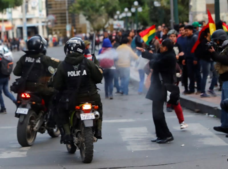 Police on motorcycles use pepper spray on demonstrators during a protest against Bolivia's President Evo Morales in La Paz