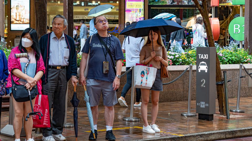 People wait for taxis at the side of the road near a taxi stand in Hong Kong, China, on May 24, 2024. - Noemi Cassanelli/CNN