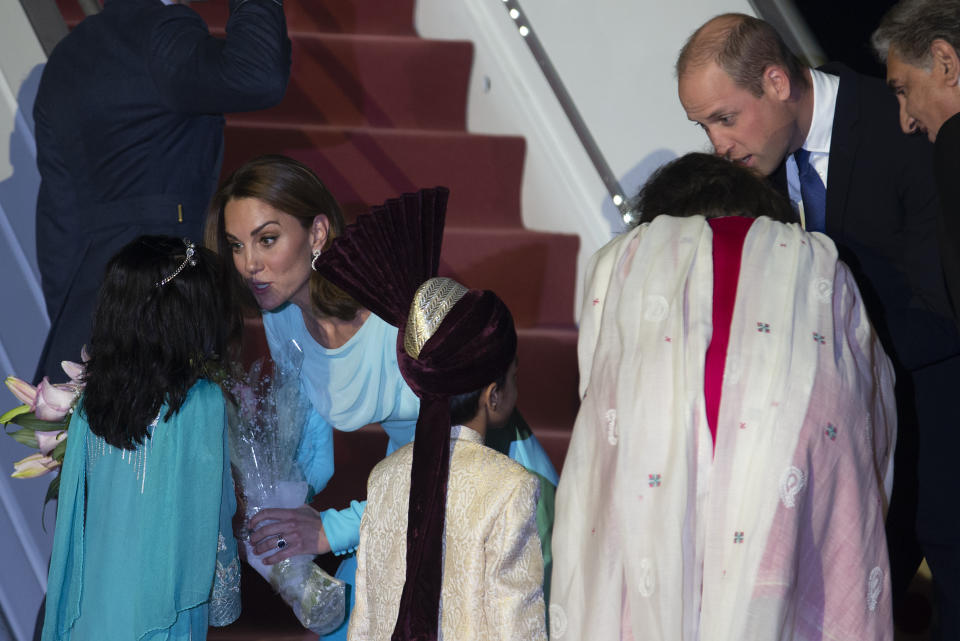 Britain's Prince William and his wife Kate receive bouquet from Pakistani children upon their arrival to Nur Khan Air Base, in Islamabad, Pakistan, Monday, Oct. 14, 2019.They are on a five-day visit, which authorities say will help further improve relations between the two countries. (AP Photo/B.K. Bangash)