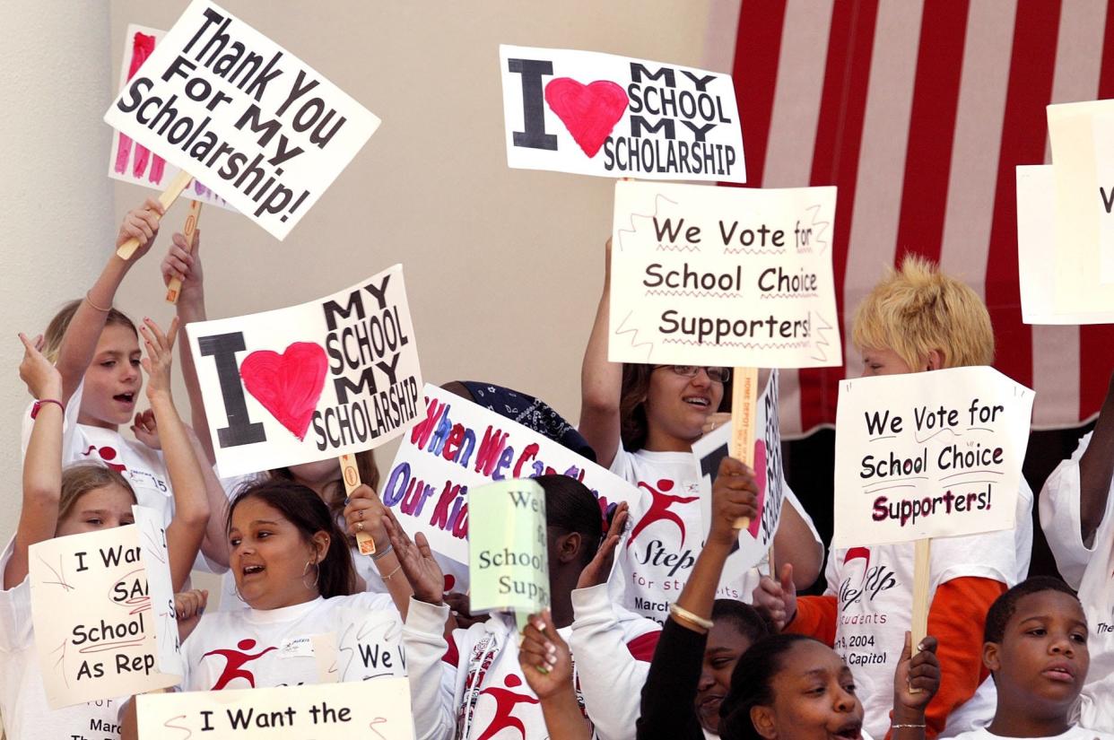 Students attending a Step Up for Students Rally cheer and wave their signs during the rally in Tallahassee.