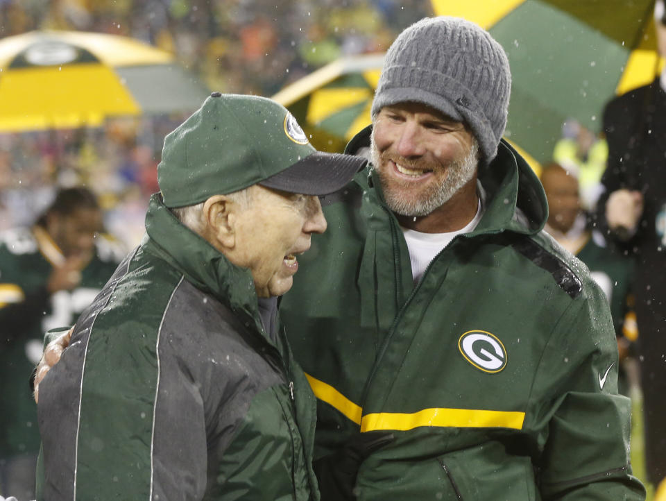 Brett Favre smiles with Bart Starr during a ceremony at halftime of an NFL football game between the Green Bay Packers and Chicago Bears Thursday, Nov. 26, 2015, in Green Bay, Wis. Favre's retired No. 4 and name were unveiled inside Lambeau Field during the ceremony. (AP Photo/Mike Roemer)