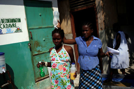 A nurse walks with a woman receiving cholera treatment at the Immaculate Conception Hospital in Les Cayes, Haiti, November 8, 2016. REUTERS/Andres Martinez Casares