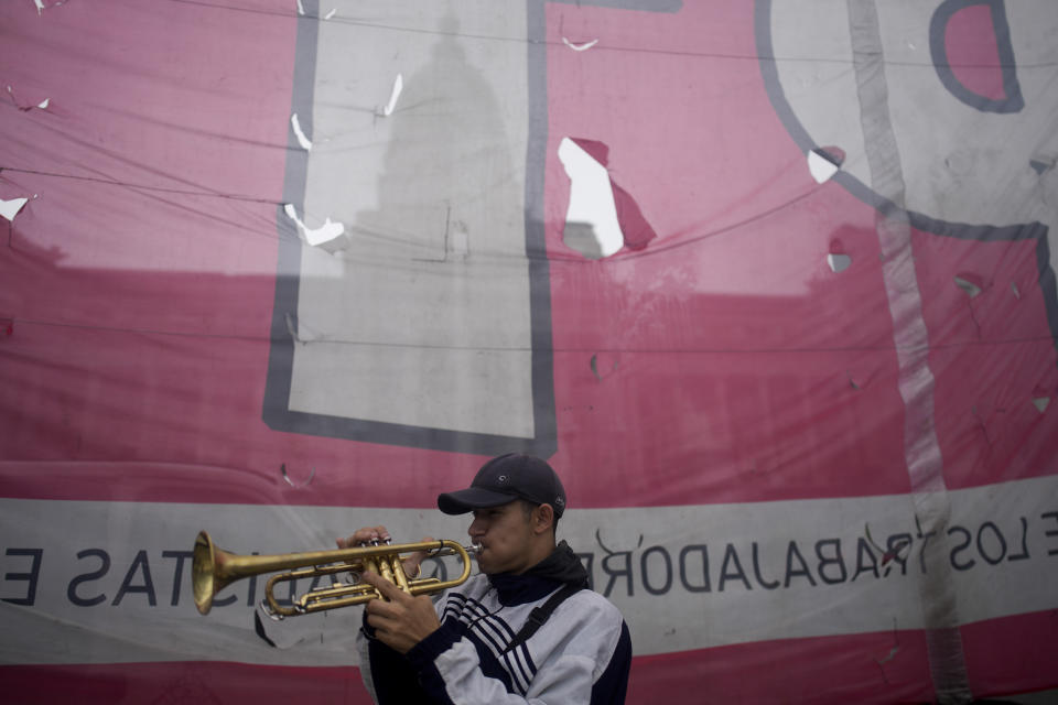 An anti-government protester plays a trumpet outside Congress where lawmakers debate a bill promoted by Argentine President Javier Milei that includes a broad range of economic, administrative, criminal and environmental reforms in Buenos Aires, Argentina, Tuesday, April 30, 2024. (AP Photo/Natacha Pisarenko)