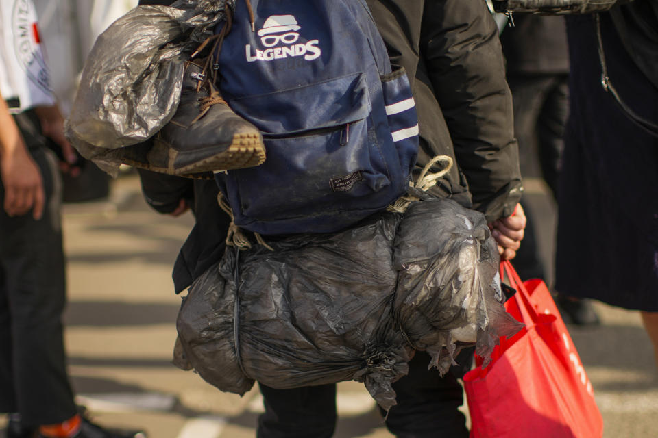 Serhii Tsybulchenko, who fled from the Azovstal steel plant in Mariupol, carries his belongs as he arrives to a reception center for displaced people in Zaporizhzhia, Ukraine, Tuesday, May 3, 2022. Evacuees from the steel plant in Mariupol are recovering and considering what to do next. (AP Photo/Francisco Seco)