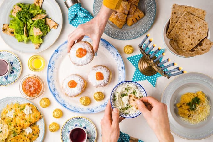 Festive feast on Hanukkah, table setting, hands over table