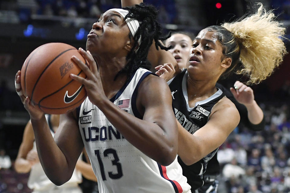 Connecticut's Christyn Williams, left, looks to shoot as Georgetown's Kaylin West, right, defends during the first half of an NCAA college basketball game in the quarterfinals of the Big East Conference tournament at Mohegan Sun Arena, Saturday, March 5, 2022, in Uncasville, Conn. (AP Photo/Jessica Hill)