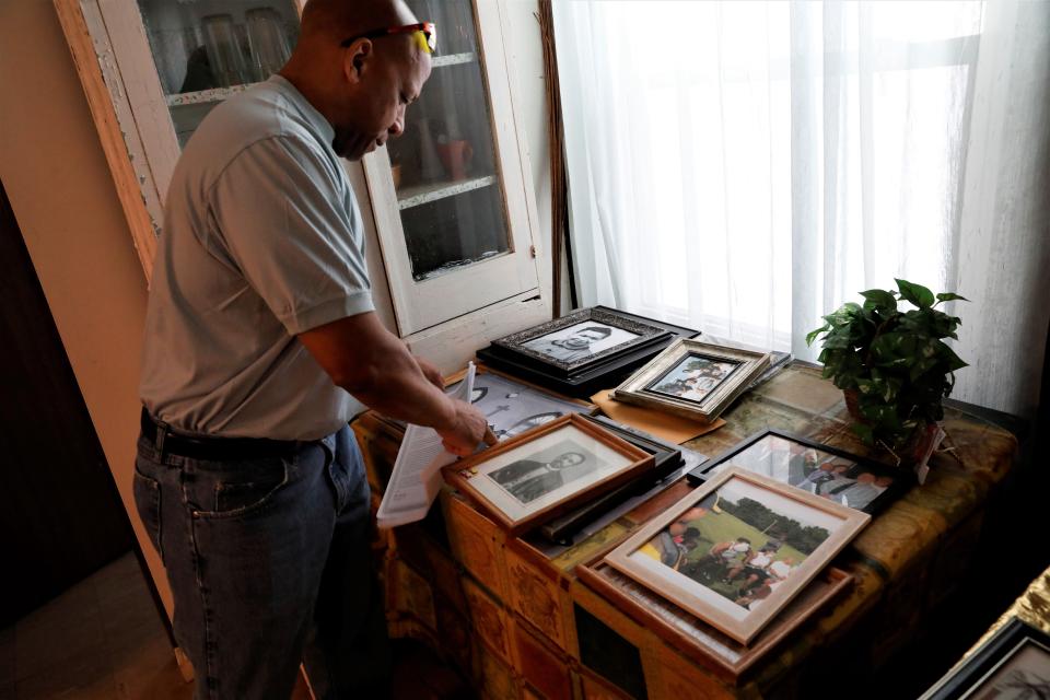 Allen Chapel Pastor Evan Saunders sorts through photos of former members and trustees of the church in this Eagle-Gazette file photo.