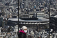 In this March 3, 2020, photo, the New National Stadium, a venue for the opening and closing ceremonies at the Tokyo 2020 Olympics, is seen from Shibuya Sky observation deck in Tokyo. Japan's Olympic minister has suggested in Parliament that the Tokyo Olympics might be pushed back a few months from it July 24 opening. The games are under threat from a spreading virus from China that has reached the pandemic stage. But the so-called “Home City Contract”signed by the International Olympic Committee and Japanese officials gives the IOC wide latitude in terminating the Olympics. (AP Photo/Jae C. Hong)