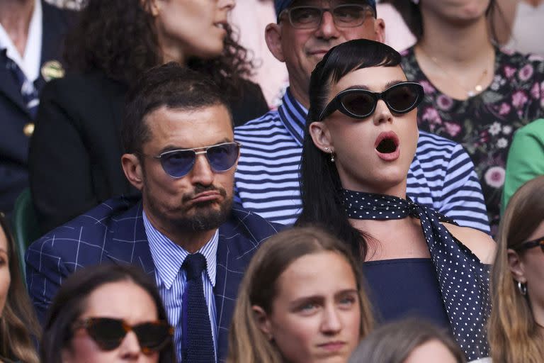 Para esta tercera fecha de Wimbledon, Orlando Bloom y Katy Perry eligieron outfits súper glamorosos y engamados. Mientras él optó por un traje a cuadros en azul oscuro, ella deslumbró con un vestido en el mismo tono que complementó con un pañuelo a lunares y unos anteojos retro