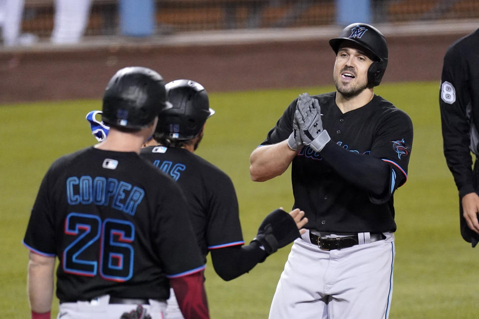 Miami Marlins' Adam Duvall, right, is congratulated by Miguel Rojas, center, and Garrett Cooper after hitting a three-run home run during the third inning of a baseball game against the Los Angeles Dodgers Friday, May 14, 2021, in Los Angeles. (AP Photo/Mark J. Terrill)