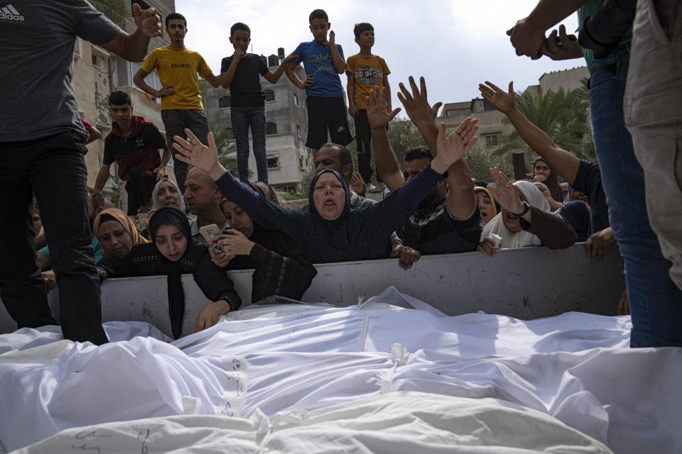 Relatives mourn people killed in an Israeli air strike in Gaza City on Monday, Oct. 9, 2023. Israel's military battled to drive Hamas fighters out of southern towns and seal its borders Monday as it pounded the Gaza Strip. (AP Photo/Fatima Shbair)