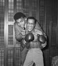 <p>Sammy Davis Jr. (right) receives a pep talk from Heavyweight Champion Cassias Clay (left) before heading out for a celebrity boxing match, January 14, 1965.</p>