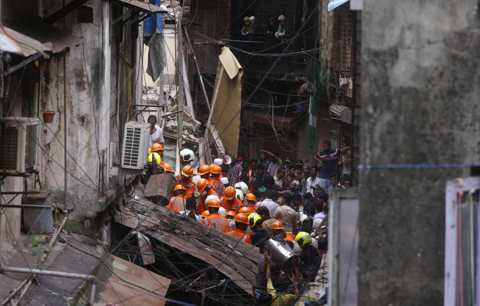 Rescuers work at the site of a building that collapsed in Mumbai, India, Tuesday, July 16, 2019. A four-story residential building collapsed Tuesday in a crowded neighborhood in Mumbai, India's financial and entertainment capital, and several people were feared trapped in the rubble, an official said. (AP Photo/Rafiq Maqbool)