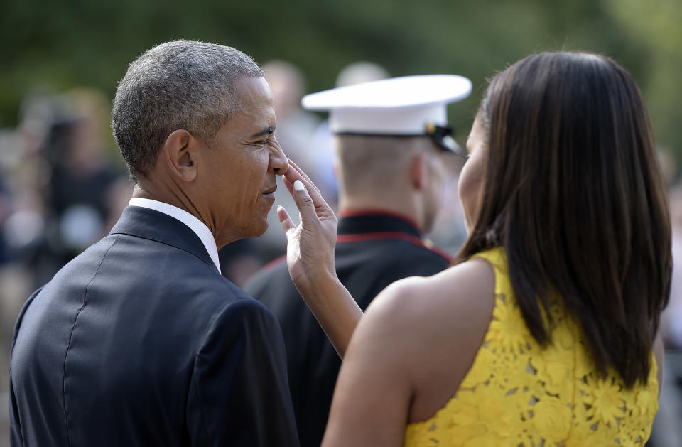 <p>Michelle adorably makes sure Barack looks tip-top to welcome the Singapore Prime Minister. <em>[Photo: Getty]</em> </p>