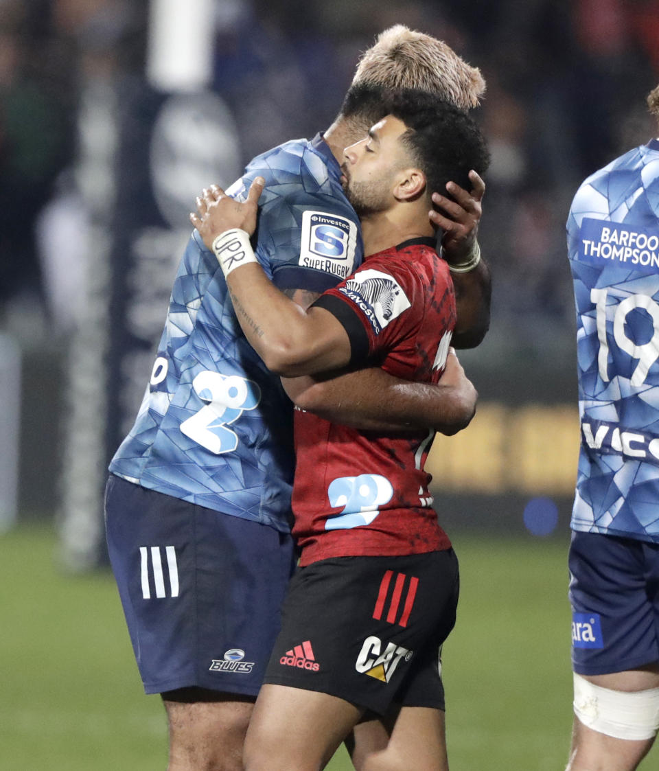 Crusaders Richie Mo'unga, right, and Blues Akira Ioane embrace following the Super Rugby Aotearoa rugby game between the Crusaders and the Blues in Christchurch, New Zealand, Saturday, July 11, 2020. (AP Photo/Mark Baker)