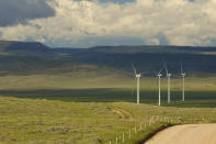 Clouds cast shadows near wind turbines at a wind farm along the Montana-Wyoming state line on Monday, June 13, 2022. The rush to build wind farms to combat climate change is colliding with preservation of one of the U.S. West's most spectacular predators, the golden eagle. Scientists say the species is teetering on the edge of decline and worry that proliferating wind turbines could push them over the brink. (AP Photo/Emma H. Tobin)