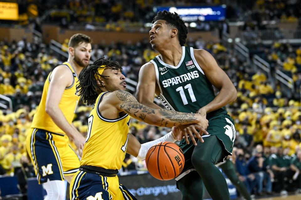 Michigan State's A.J. Hoggard, right, loses the ball after the defense of Michigan's Frankie Collins during the first half on Tuesday, March 1, 2022, at the Crisler Center in Ann Arbor.