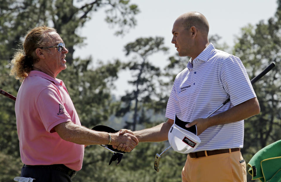 Miguel Angel Jimenez, of Spain, shakes hands with Bill Haas, right, on the 18th green following their first round of the Masters golf tournament Thursday, April 10, 2014, in Augusta, Ga. (AP Photo/David J. Phillip)