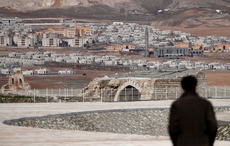 Ridvan Ayhan, an activist and a former resident of Hasankeyf, strolls in a canyon with new Hasankeyf in the background in Batman province