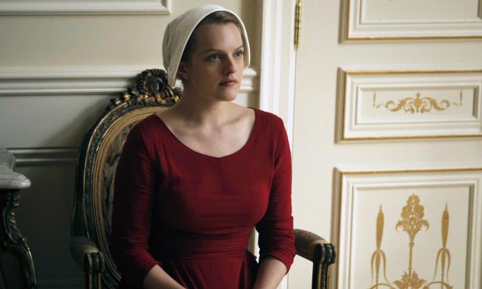 Woman in a red gown and white mob hat sitting down