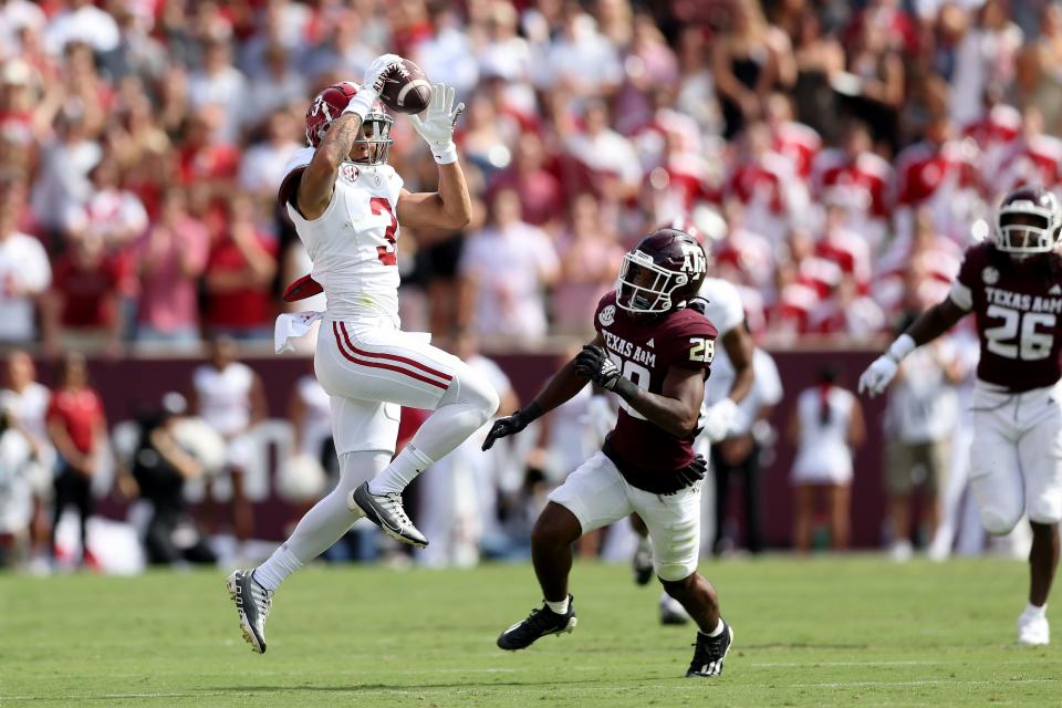 Alabama wide receiver Jermaine Burton catches a pass in front off Texas A&M defender Josh DeBerry during the first half at Kyle Field on October 07, 2023 in College Station, Texas.