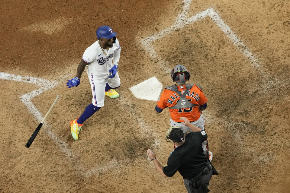 Texas Rangers' Adolis Garcia, left, drops his bat as he confronts Houston Astros catcher Martin Maldonado (15) after being hit by a pitch thrown by relief pitcher Bryan Abreu during the eighth inning in Game 5 of the baseball American League Championship Series Friday, Oct. 20, 2023, in Arlington, Texas. (AP Photo/Godofredo A. Vásquez)