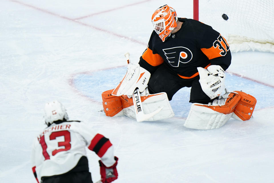 Philadelphia Flyers' Brian Elliott, right, cannot stop a goal by New Jersey Devils' Nico Hischier during the third period of an NHL hockey game, Saturday, May 1, 2021, in Philadelphia. (AP Photo/Matt Slocum)