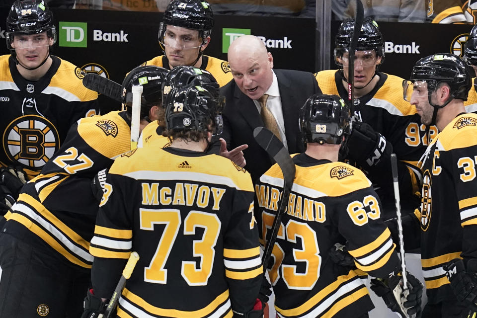 Boston Bruins head coach Jim Montgomery talks with his players during a time out in the first period of an NHL hockey game against the Ottawa Senators, Tuesday, March 21, 2023, in Boston. (AP Photo/Charles Krupa)