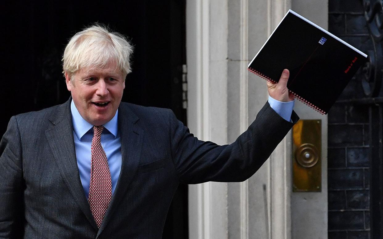 Boris Johnson reacts as he leaves 10 Downing Street as the government upgraded its coronavirus alert level - BEN STANSALL/AFP
