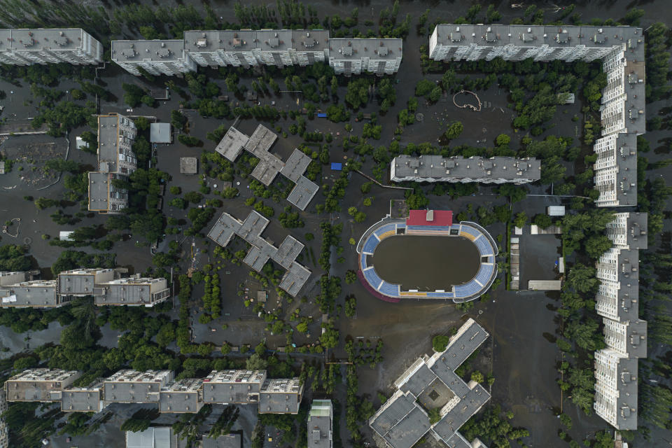 Houses and stadium are seen underwater and polluted by oil in the flooded Kherson, Ukraine, Saturday, June 10, 2023. The destruction of the Kakhovka Dam in southern Ukraine is swiftly evolving into long-term environmental catastrophe. It affects drinking water, food supplies and ecosystems reaching into the Black Sea. (AP Photo)