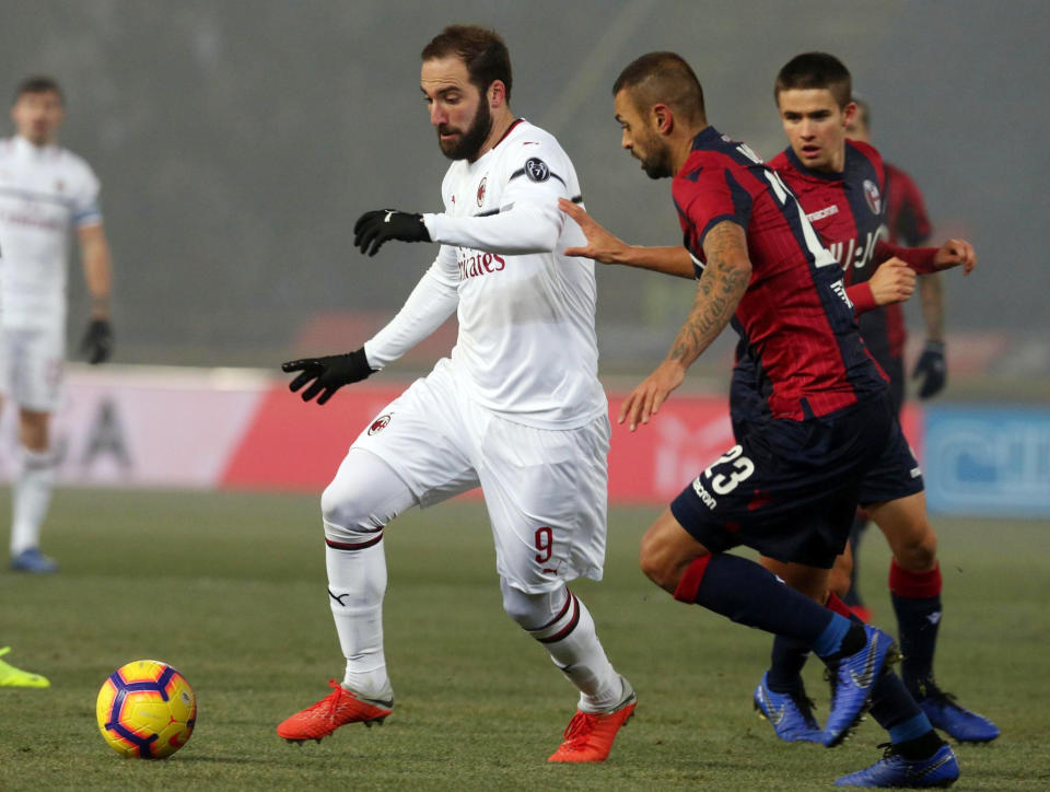 Milan's Gonzalo Higuain, left, and Bologna's Larangeira Danilo vie for the ball during the Italian Serie A soccer match between Bologna and Milan at "Dall'Ara" stadium in Bologna, Italy, Tuesday, Dec. 18, 2018. (Giorgio Benvenuti/ANSA via AP)