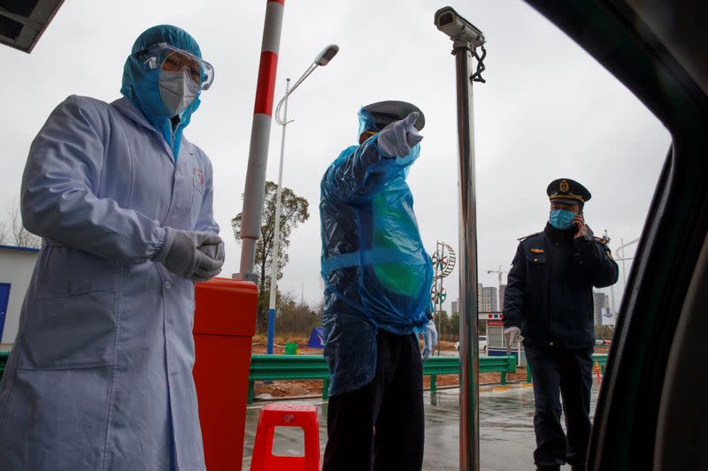 A medical worker and police stand at a checkpoint as the country is hit by an outbreak of the novel coronavirus in Susong County