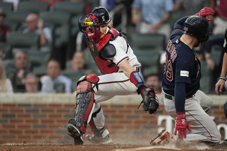 Boston Red Sox' Alex Verdugo (99) beats the tag from Atlanta Braves catcher Sean Murphy (12) to score on a Justin Turner sacrifice fly in the third inning of a baseball game Tuesday, May 9, 2023, in Atlanta. (AP Photo/John Bazemore)
