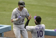 Colorado Rockies' Trevor Story, left, celebrates and social distances with manager Bud Black after hitting a solo home run during the third inning of a baseball game against the Los Angeles Dodgers in Los Angeles, Sunday, Aug. 23, 2020. (AP Photo/Alex Gallardo)