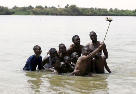 A group of young men use a selfie stick to take a picture of themselves in shallow waters known as the first cataract of the River Nile outside Khartoum, Sudan, in this May 22, 2015 file photo. REUTERS/Mohamed Nureldin Abdallah/Files