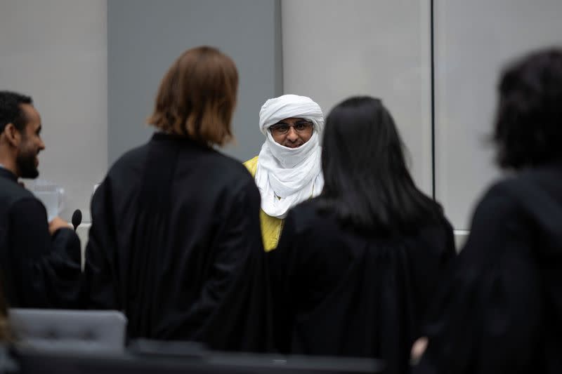 Al Hassan Ag Abdoul Aziz Ag Mohamed Ag Mahmoud talks to his defence counsel in the courtroom of the International Criminal Court in The Hague