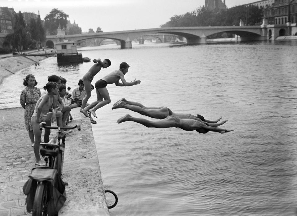 People dive into the Seine river near the Pont du Carrousel, in July 1949 in Paris, while a heat wave hits the capital.<span class="copyright">AFP/Getty Images</span>