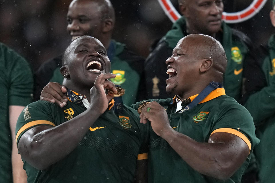 South Africa's Trevor Nyakane, left, and Mbongeni Mbonambi celebrate during the presentation ceremony after the Rugby World Cup final match between New Zealand and South Africa at the Stade de France in Saint-Denis, near Paris Saturday, Oct. 28, 2023. South Africa won the match 12-11. (AP Photo/Thibault Camus)