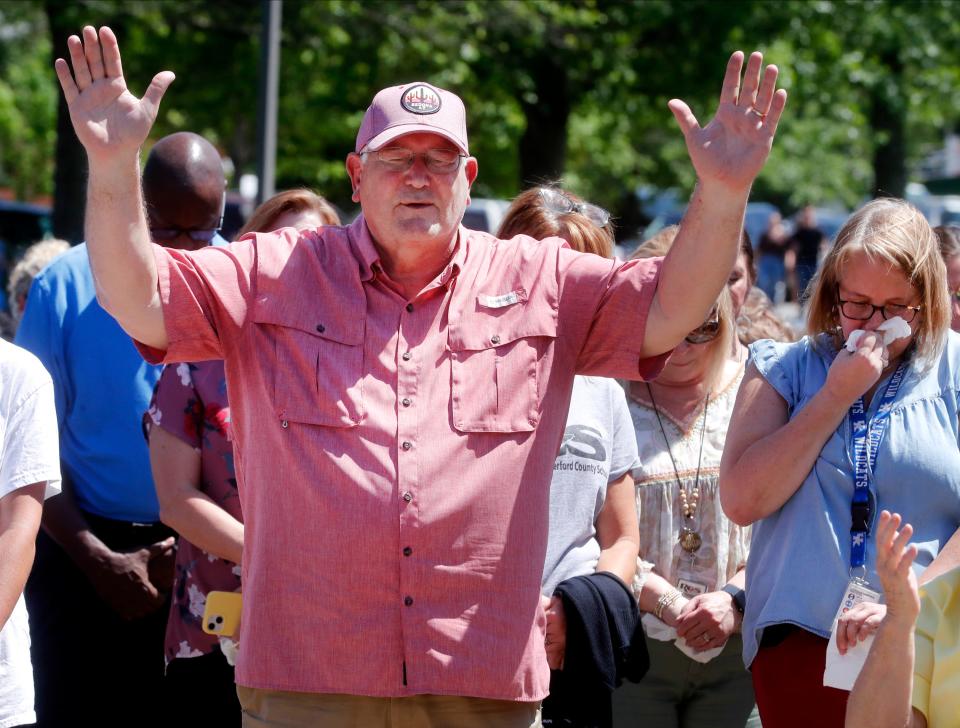 Ray Frost lifts his hands in prayer during a prayer vigil with others on Thursday, May 9, 2024, for Asher Sullivan, the son of Superintendent/Director of Schools at Rutherford County Schools James “ Jimmy” Sullivan, who was involved in a tragic accident last night after the storm, on Wednesday. The vigil was held in the parking lot of the Rutherford County School Central Office.