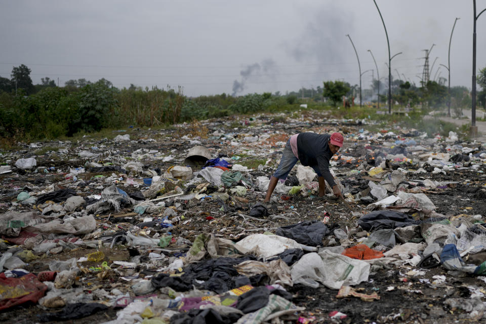 A man looks into the garbage for anything useful in Tucuman, Argentina, Thursday, March 30, 2023. (AP Photo/Natacha Pisarenko)